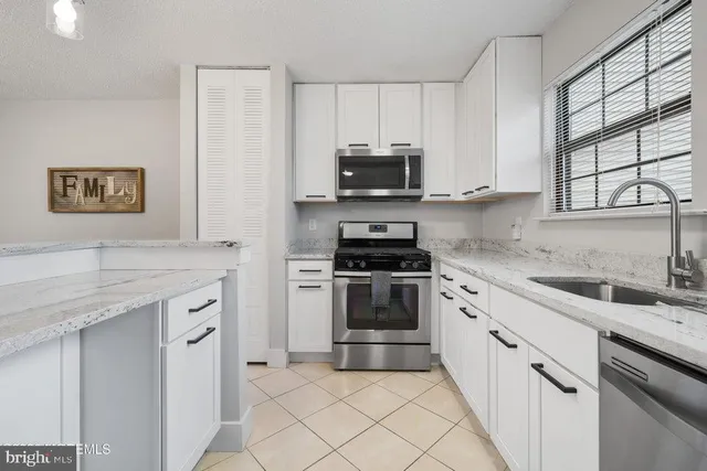 a kitchen with granite countertop a sink and steel appliances