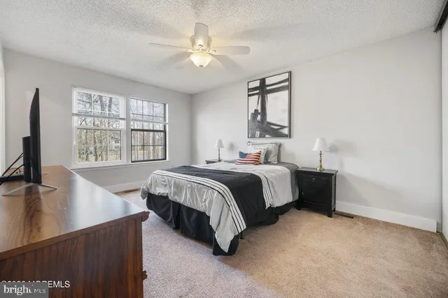 a bedroom with a bed window and a flat screen tv