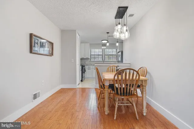 a view of a dining room with furniture a chandelier and wooden floor