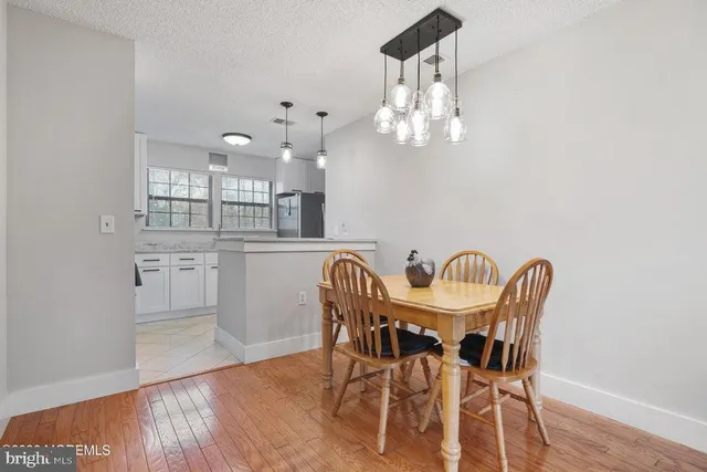 a view of a dining room with furniture a chandelier and wooden floor