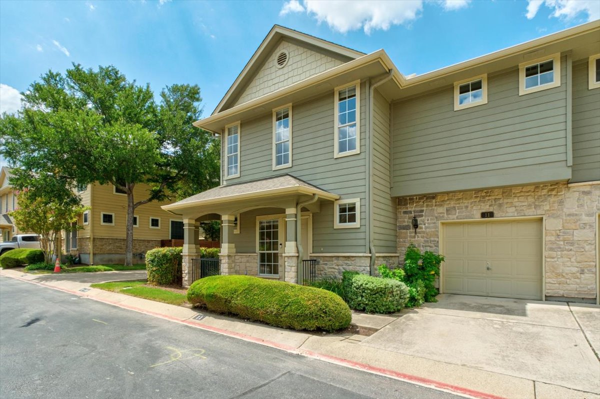 11000 Anderson Mill Road, Unit 11 Austin, TX 78750 - Photo 2 of 34 Green siding and stone accents highlight this welcoming two-story residence with an integrated garage.