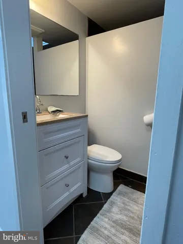 a bathroom with a toilet a sink a vanity and mirror
