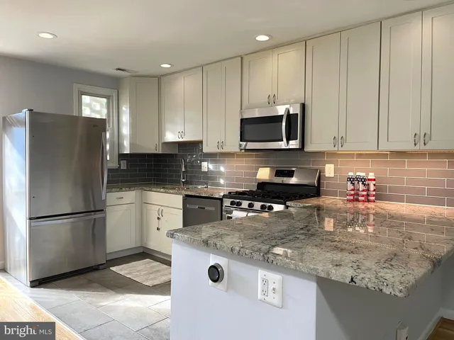 a large kitchen with wooden floor and a sink