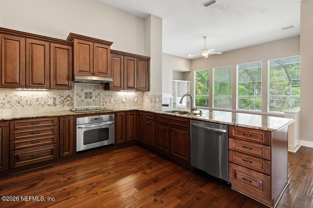 337 South Mill View Way Ponte Vedra Beach, FL 32082 - Photo 15 of 63 a kitchen with stainless steel appliances granite countertop a stove a sink dishwasher and a microwave oven with cabinets