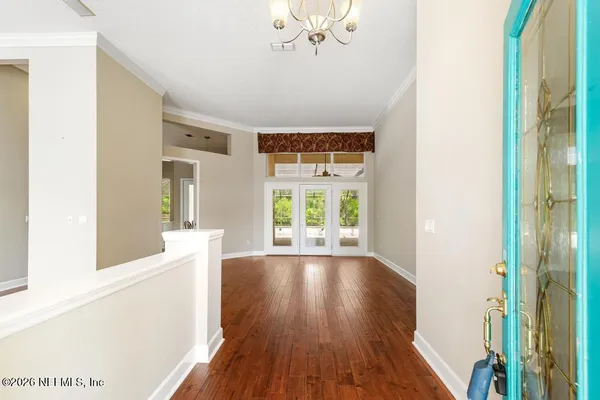 a view of an empty room with wooden floor and closet