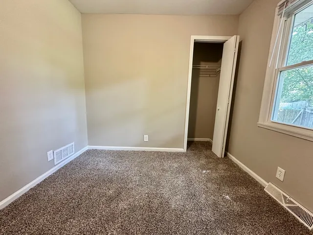 an empty room with windows and closet