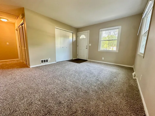 an empty room with windows and closet