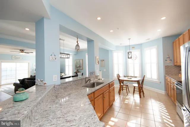a living room with furniture a flat screen tv and large windows