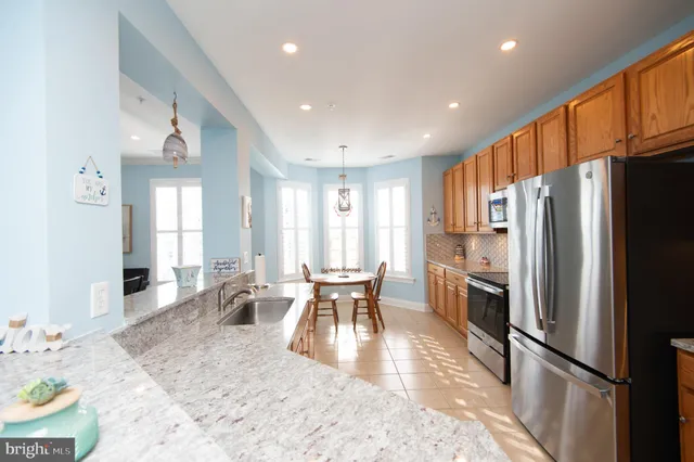 a kitchen with stainless steel appliances granite countertop a refrigerator and a sink