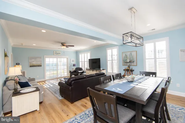 a view of a dining room and livingroom with furniture window and wooden floor