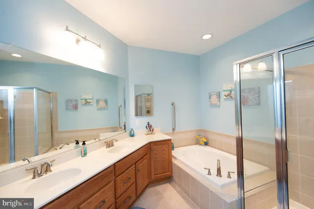 a bathroom with a tub double vanity sink and a mirror