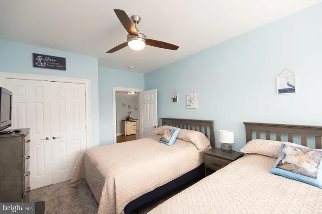 a bedroom with two beds and painting on the wall