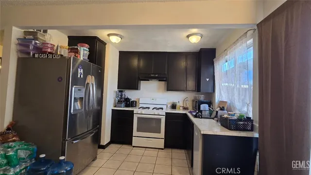 a kitchen with stainless steel appliances granite countertop a refrigerator and a sink