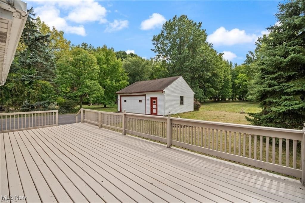 25096 Highland Road Cleveland, OH 44143 - Photo 31 of 34 Deck with a garage, an outdoor structure, and a lawn