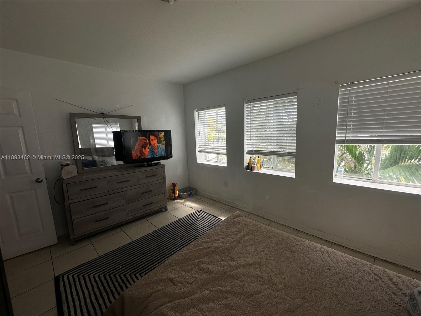 1021 Northwest 3rd Street, Unit 305 Miami, FL 33128 - Photo 14 of 22 a living room with furniture and a flat screen tv
