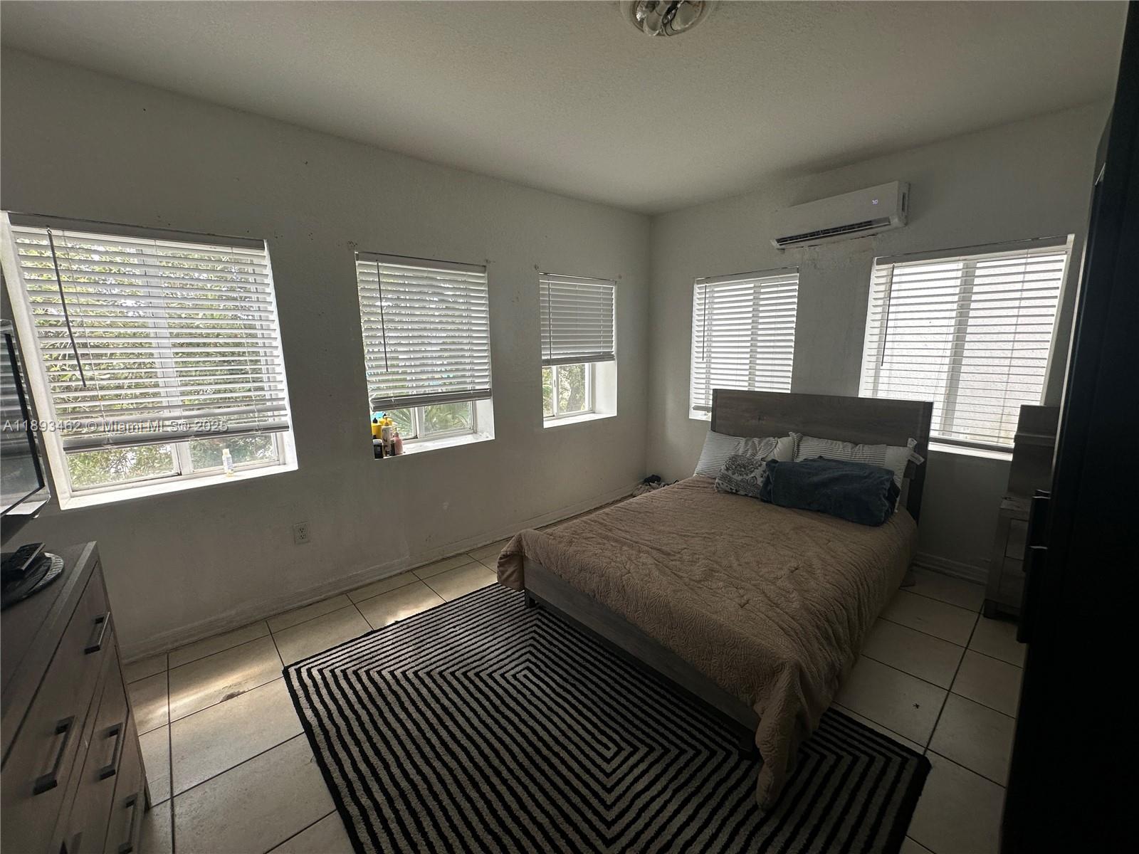 1021 Northwest 3rd Street, Unit 305 Miami, FL 33128 - Photo 15 of 22 a bedroom with a bed and wooden floor