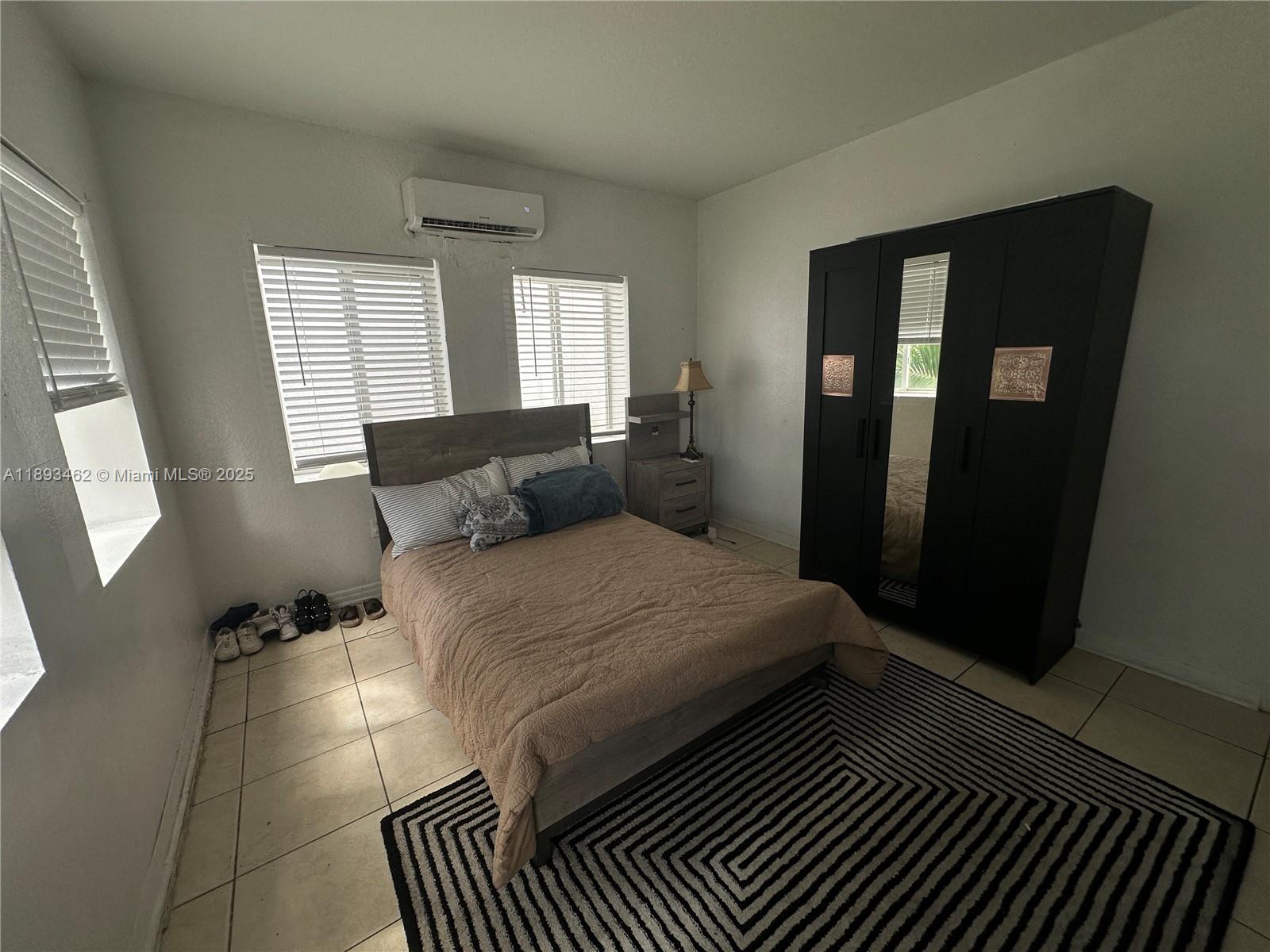1021 Northwest 3rd Street, Unit 305 Miami, FL 33128 - Photo 16 of 22 a bedroom with bed and window