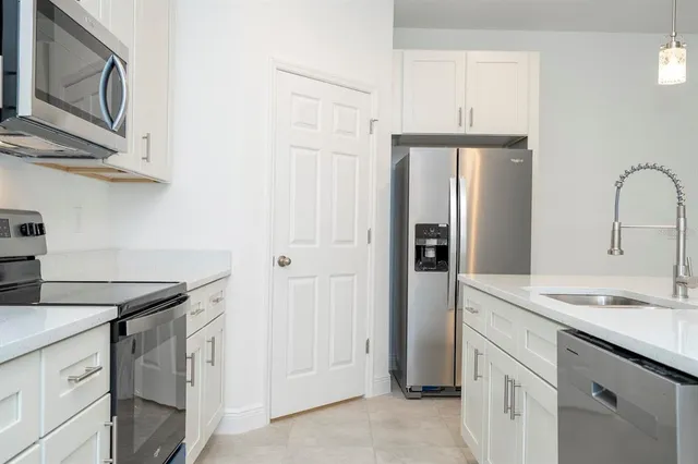 a kitchen with stainless steel appliances granite countertop a sink a stove and a microwave