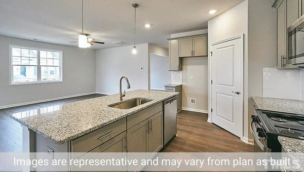 a kitchen with a sink refrigerator and cabinets
