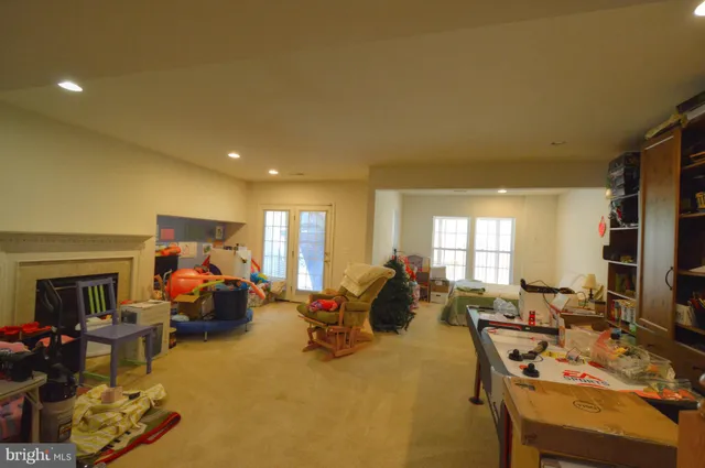 a living room filled with furniture a window and a flat screen tv