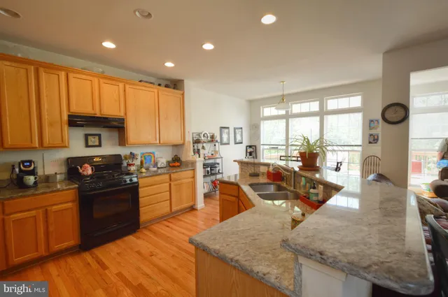 a kitchen with stainless steel appliances granite countertop sink stove top oven and cabinets