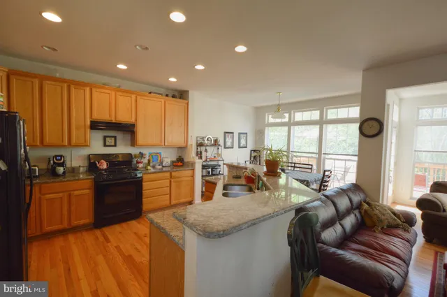 a kitchen with stainless steel appliances granite countertop sink stove top oven and cabinets