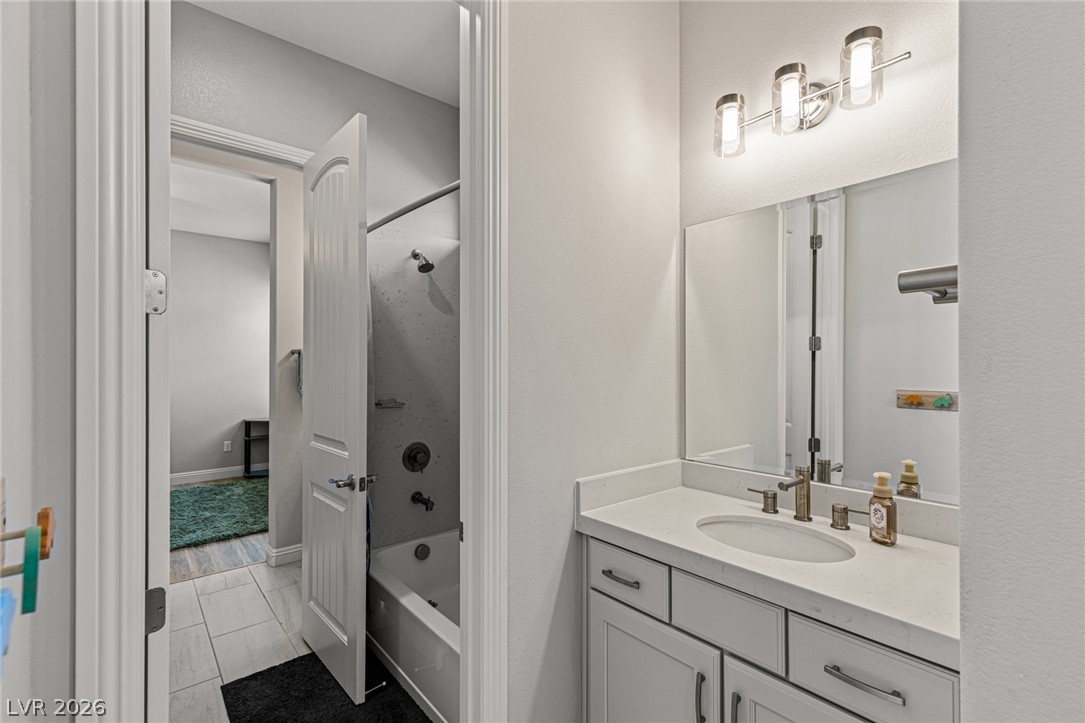 7036 Arabian Ridge Street Las Vegas, NV 89131 - Photo 36 of 64 Bathroom with Dual Sinks and a Tub and Shower combo between bedrooms 2 and 3.