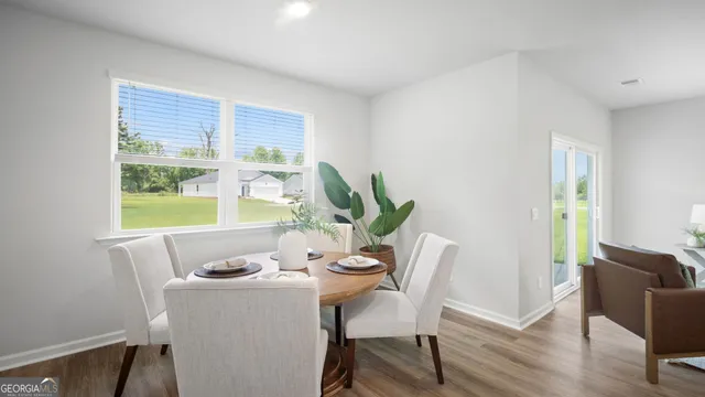 a dining room with furniture potted plants and wooden floor