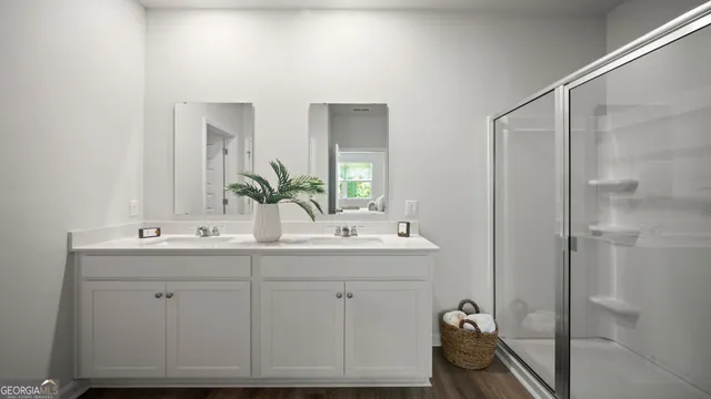 a bathroom with a double vanity sink mirror and shower
