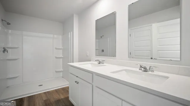 a bathroom with a sink shower and a mirror