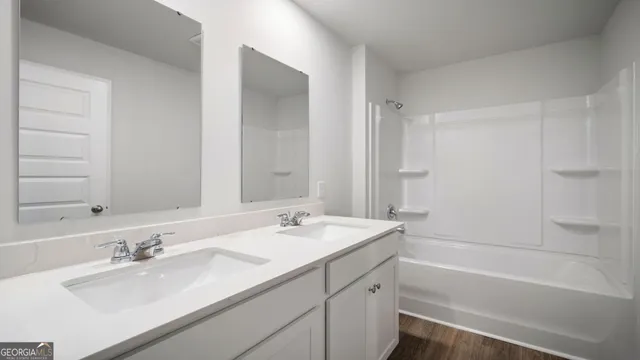 a bathroom with a tub sink double vanity and mirror
