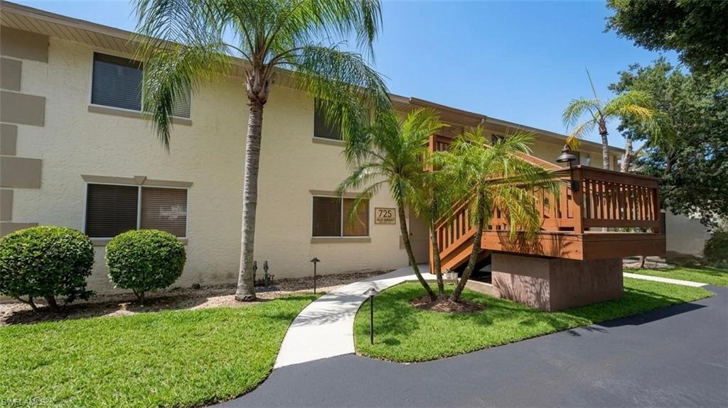 5410 16th Place Southwest, Unit B1 Naples, FL 34116 - Photo 1 of 26 a front view of a house with garden