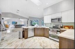 8370 Whispering Oak Way West Palm Beach, FL 33411 - Photo 7 of 14 a kitchen with kitchen island a stove sink and cabinets
