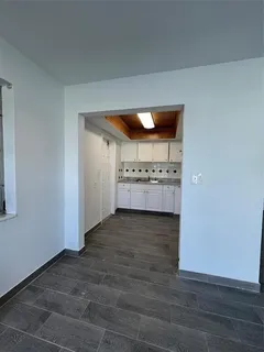 an empty room with a wooden floor and cabinet