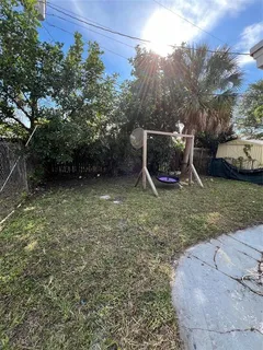a view of a backyard with wooden fence