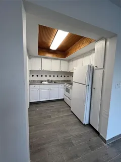 a kitchen with stainless steel appliances granite countertop a refrigerator a sink a stove and white cabinets