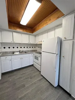 a kitchen with cabinets a sink and white appliances