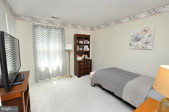 a spacious bedroom with a bed and a window