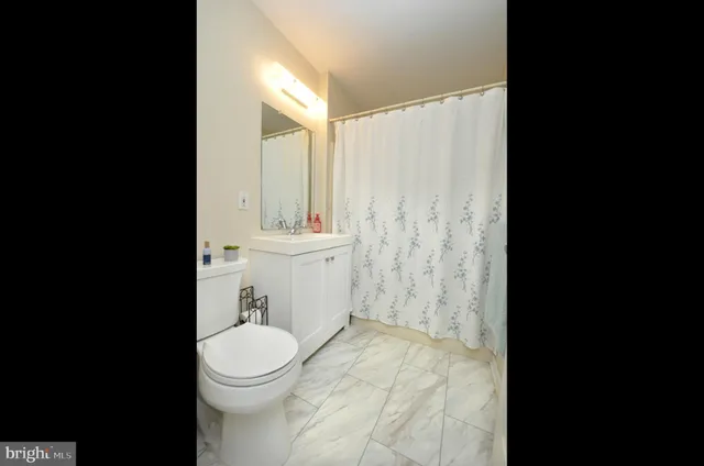 a white toilet sitting next to a bathroom sink