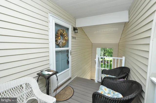 a porch with a couch and a potted plant