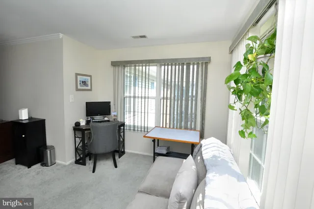 a view of a workspace with furniture and a window