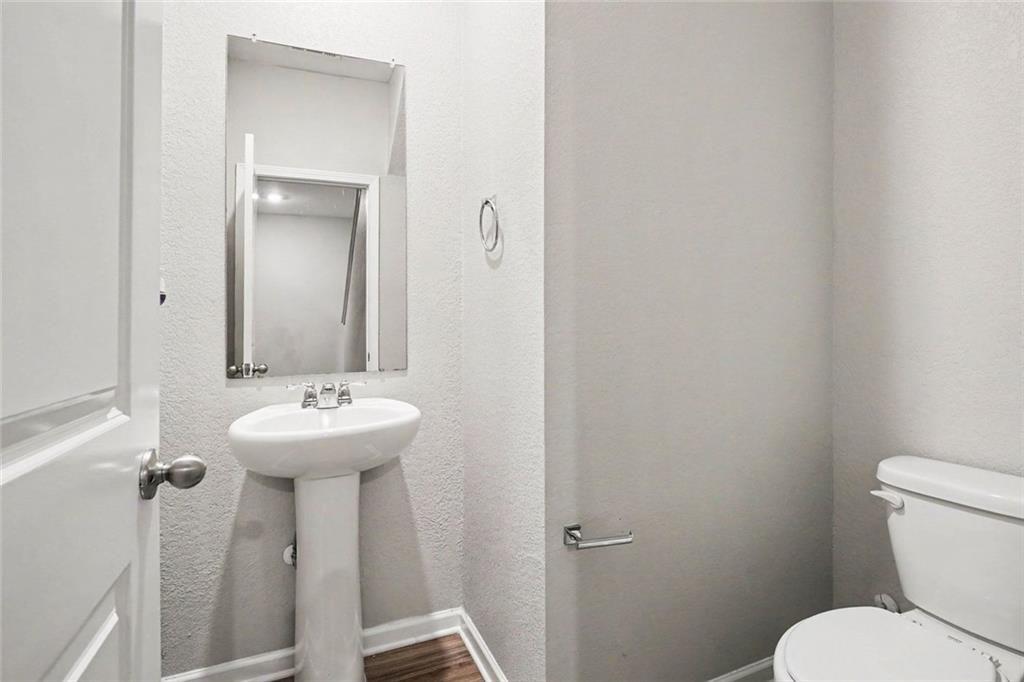 10941 Wheeler Trace Hampton, GA 30228 - Photo 18 of 21 a bathroom with sink a toilet and mirror