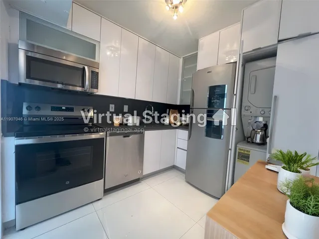 a kitchen with stainless steel appliances kitchen island granite countertop a refrigerator stove and sink