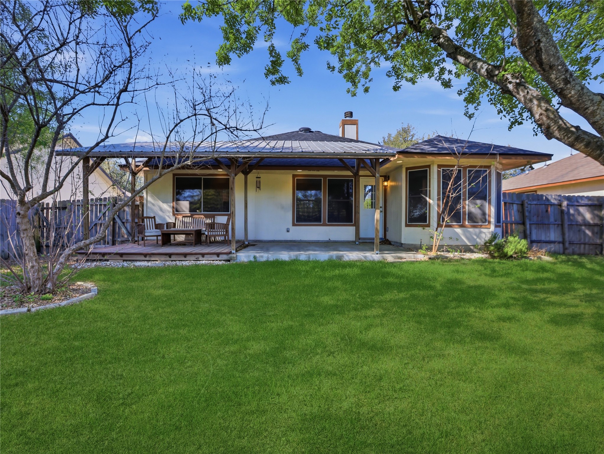 168 Keystone Loop Kyle, TX 78640 - Photo 21 of 23 Rear view of property with a chimney, stucco siding, and a wooden deck