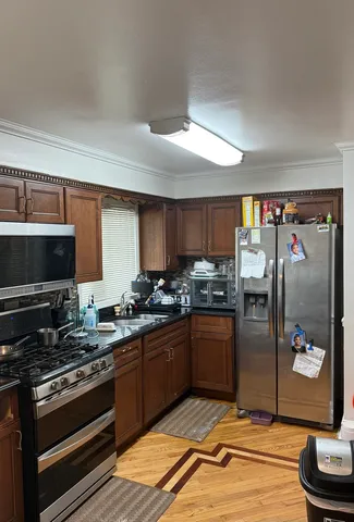 a kitchen with stainless steel appliances granite countertop a stove a sink and a refrigerator