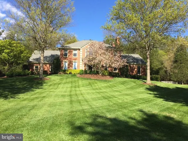 a view of a house with a big yard and large trees