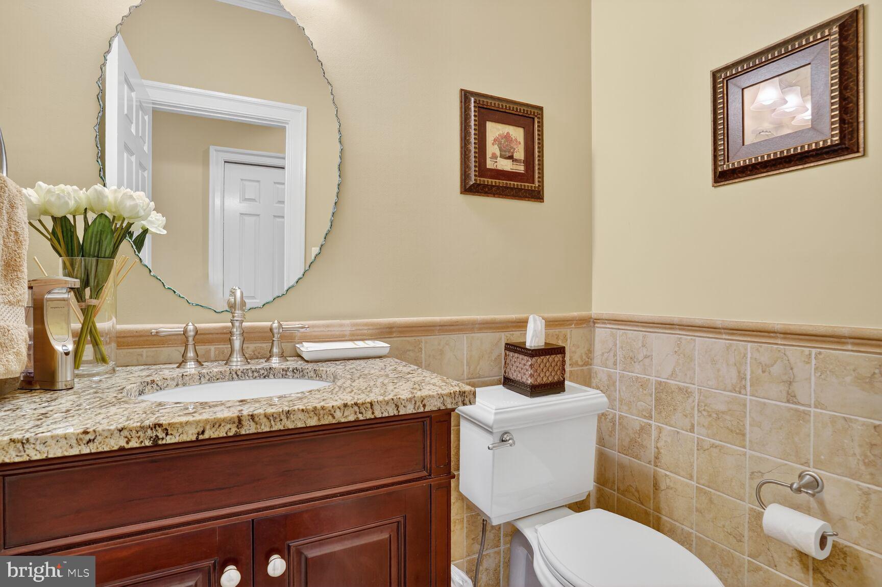 6705 Cedar View Court Clifton, VA 20124 - Photo 28 of 72 a bathroom with a granite countertop toilet sink and mirror