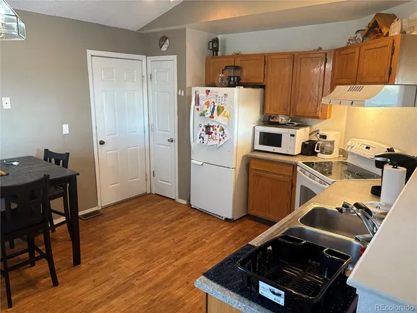 a kitchen with a refrigerator and a stove top oven