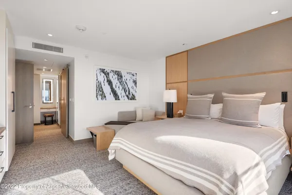 a spacious bedroom with a bed and a large window