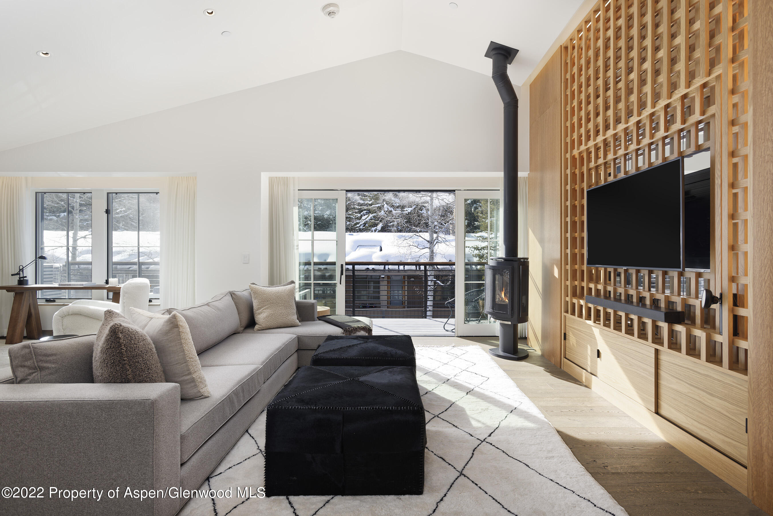 550 South Spring Street, Unit 392 Aspen, CO 81611 - Photo 3 of 41 a living room with furniture a flat screen tv and a floor to ceiling window